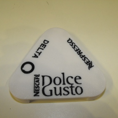 Tampa plástica branca triangular com inscrições NESCAFÉ Dolce Gusto, DELTA e NESPRESSO