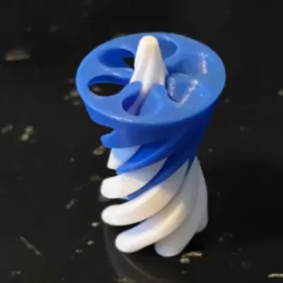 Peça 3D azul e branca em forma helicoidal sobre superfície preta