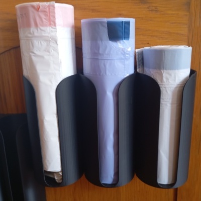 Suportes pretos com rolos de plástico em parede de madeira