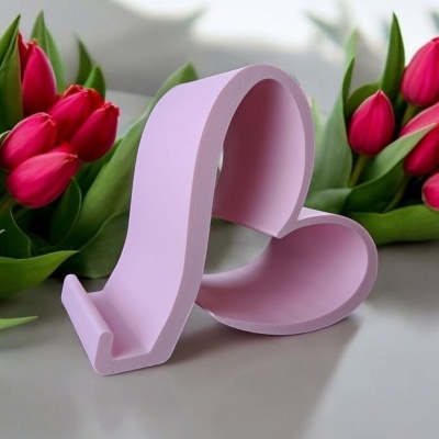 Suporte rosa para telemóvel em forma de coração com tulipas vermelhas ao fundo