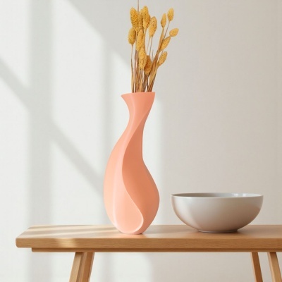 Vaso decorativo cor de pêssego com ramos secos e tigela branca numa mesa de madeira