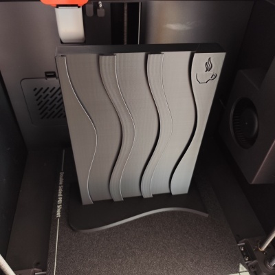 Objeto impresso em 3D cinza com ondas verticais e ícone de chávena de café