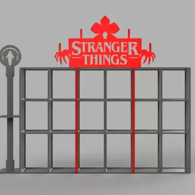 Estante metálica cinza com decoração vermelha STRANGER THINGS e suporte com figura de pessoa com auscultadores.
