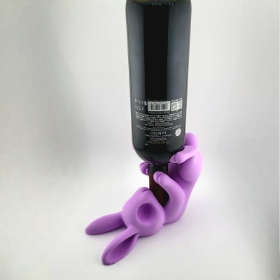 Suporte para garrafa lilás em forma de coelho segurando garrafa preta