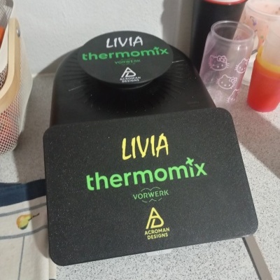 Base preta com texto LIVIA thermomix VORWERK ACROMAN DESIGNS numa bancada de cozinha