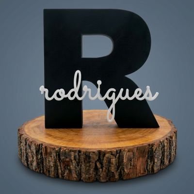 Letra decorativa preta R com nome rodrigues branco sobre base de madeira