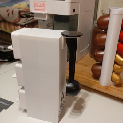 Máquina de café branca com suporte de cápsulas coloridas