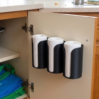 Organizador de sacos de plástico pretos montado em porta de armário com rolos de sacos brancos