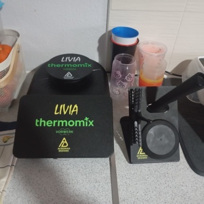 Suporte preto para Thermomix com texto LIVIA e copos Hello Kitty em bancada de cozinha