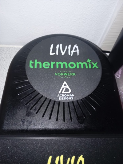 Tampa preta de eletrodoméstico com texto e logo