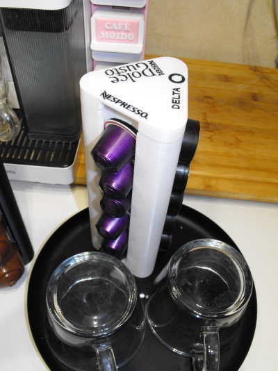 Suporte triangular branco para cápsulas Nespresso com chávenas de café em bandeja preta