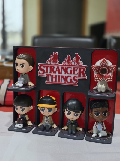Conjunto de bonecos em PVC com personagens da série Stranger Things num suporte preto e vermelho.