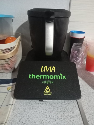 Tampa preta personalizada para Thermomix com nome LIVIA e logos em bancada de cozinha.