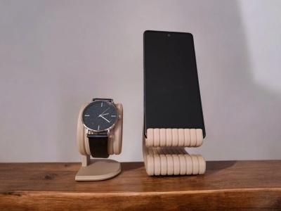 Suportes de madeira bege para relógio e smartphone sobre mesa de madeira