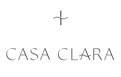 Logótipo CASA CLARA em preto sobre fundo branco com um símbolo de cruz acima