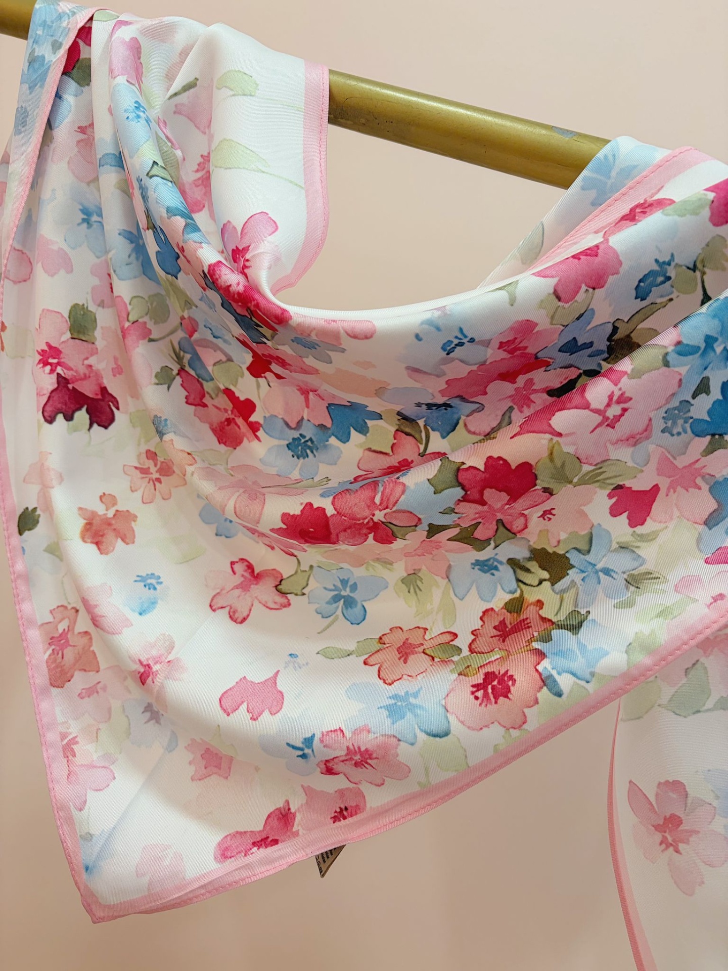 BANDANA SHEILA Lenço floral colorido pendurado numa barra metálica