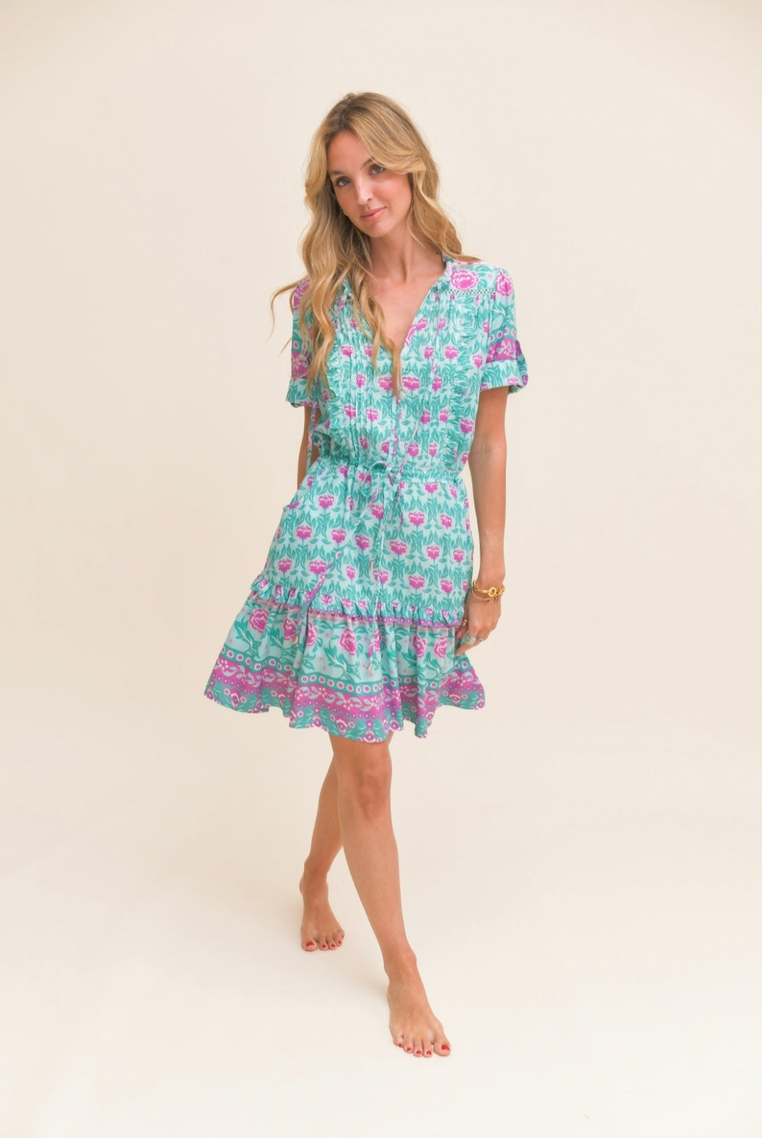 VESTIDO BOREAL CURTO Vestido curto floral verde, rosa e roxo com cintura ajustável em fundo neutro