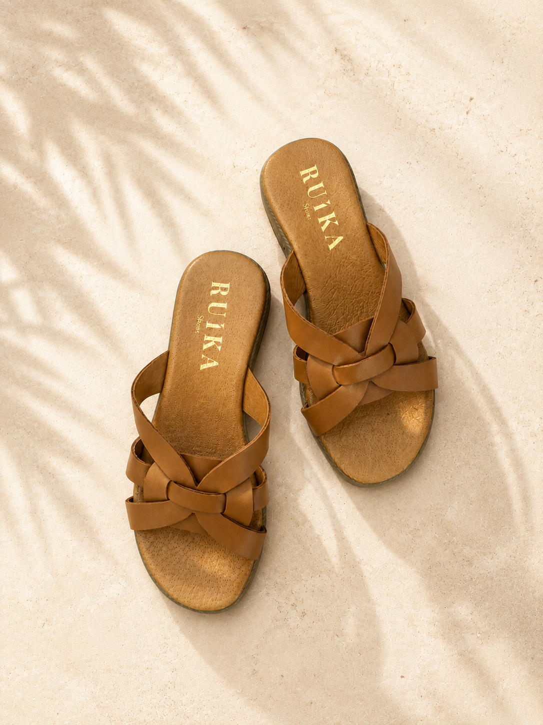 CHINELOS VÉLIA CAMEL Sandálias castanhas de tiras entrelaçadas em superfície clara com sombra de folhas