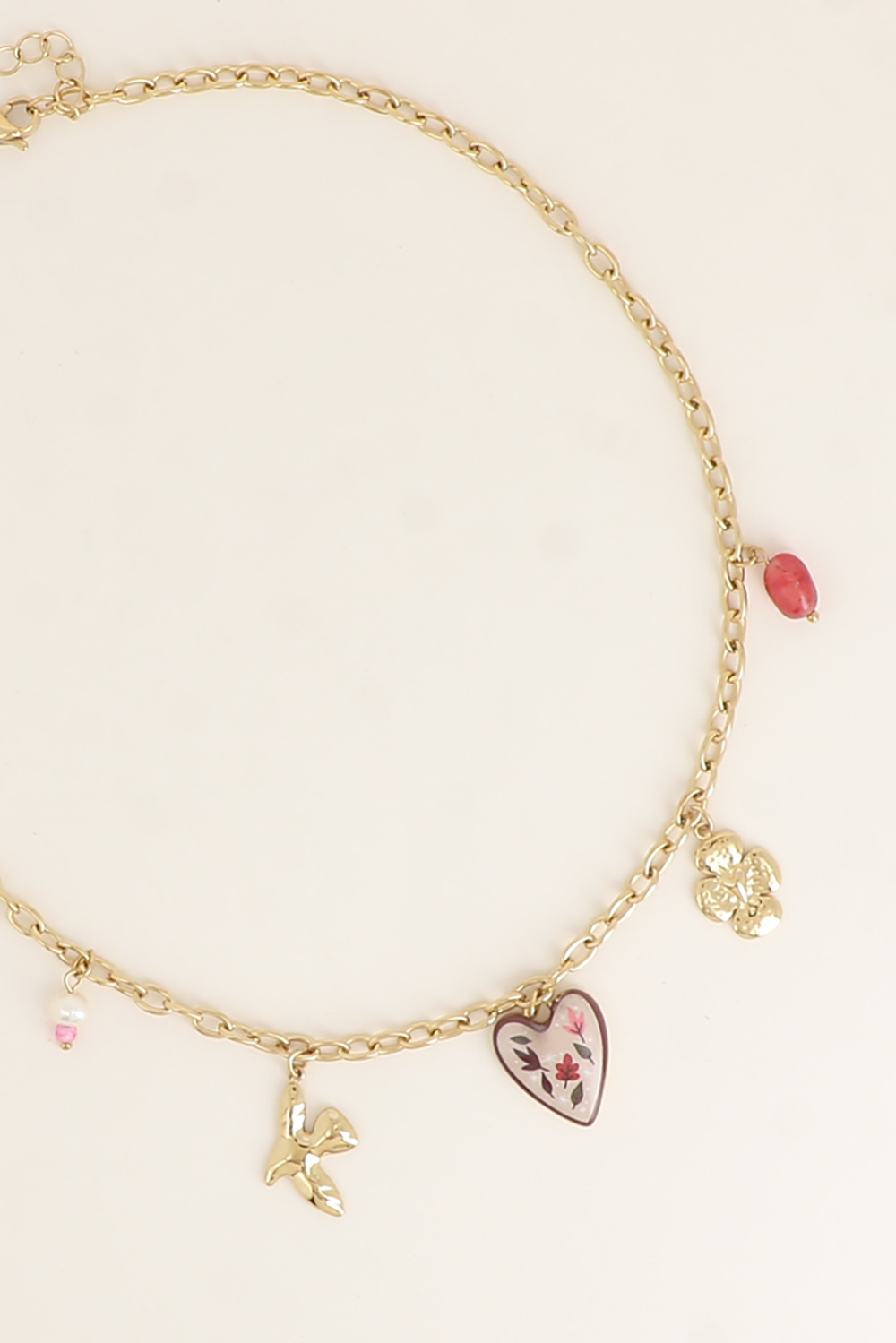 COLAR AMORA Colar dourado com quatro pendentes variados com motivos de pássaro, flor, coração floral e pérolas cor-de-rosa.