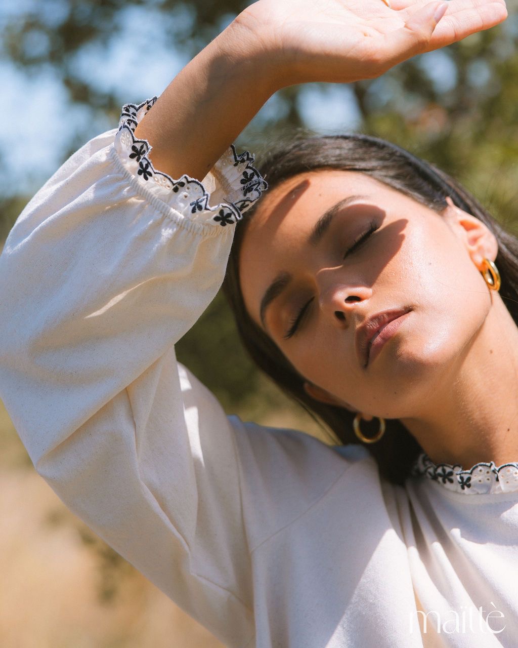 BLUSA ARUNA Blusa branca com renda preta e branca nos punhos em mulher ao sol