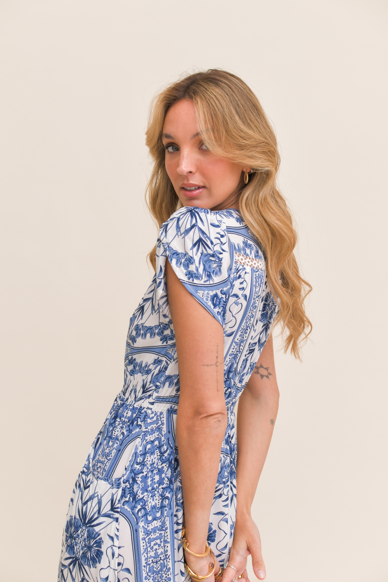VESTIDO DENIM DREAMS COMPRIDO Mulher loira de vestido azul e branco estampado com padrão floral e geométrico