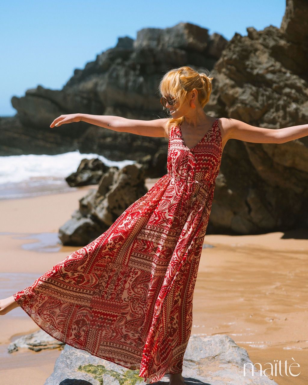 VESTIDO ZEFERINA Vestido longo vermelho e branco com padrão, usado numa praia com rochas