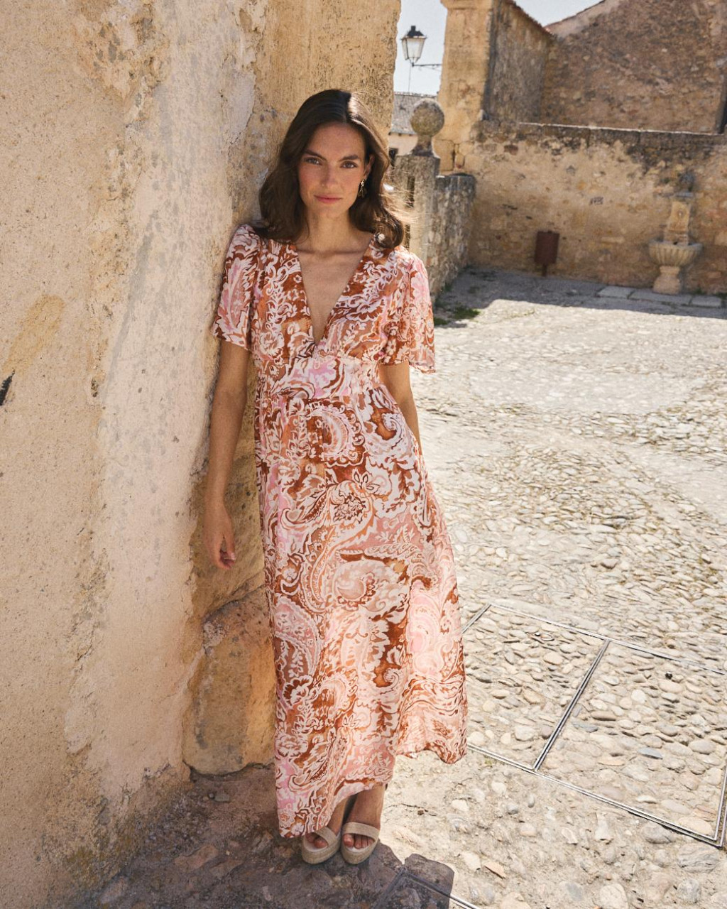VESTIDO RUBY Vestido comprido rosa, branco e castanho com padrão ondulado e decote em V.
