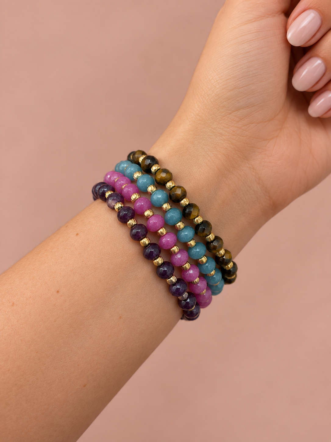 PULSEIRAS BENÍCIA Pulseiras coloridas de contas facetadas em pulso feminino.