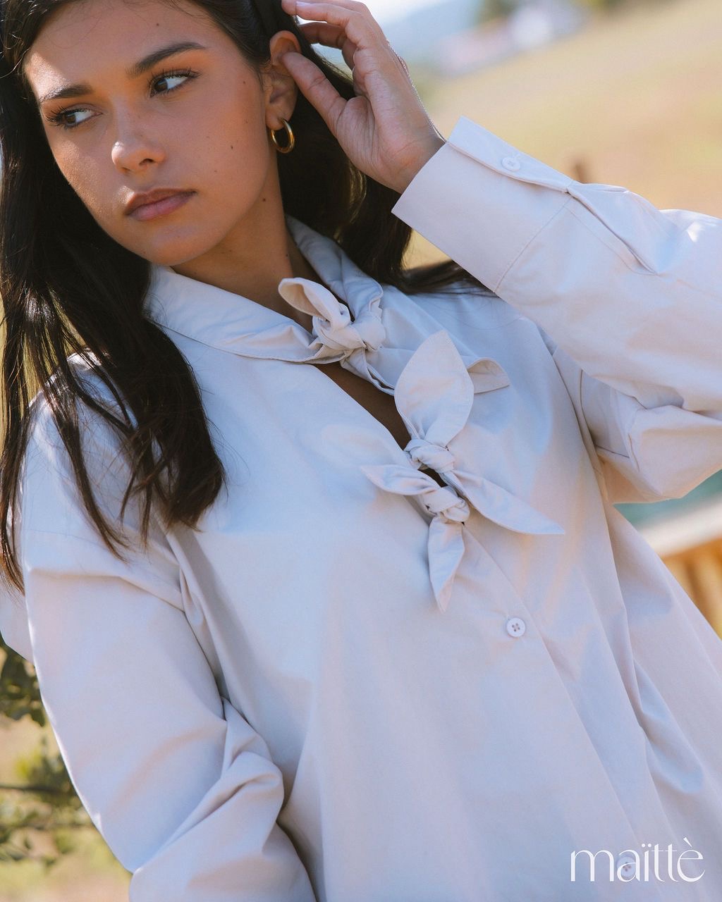 CAMISA ASPÁSIA Blusa branca com nós decorativos em mulher ao ar livre