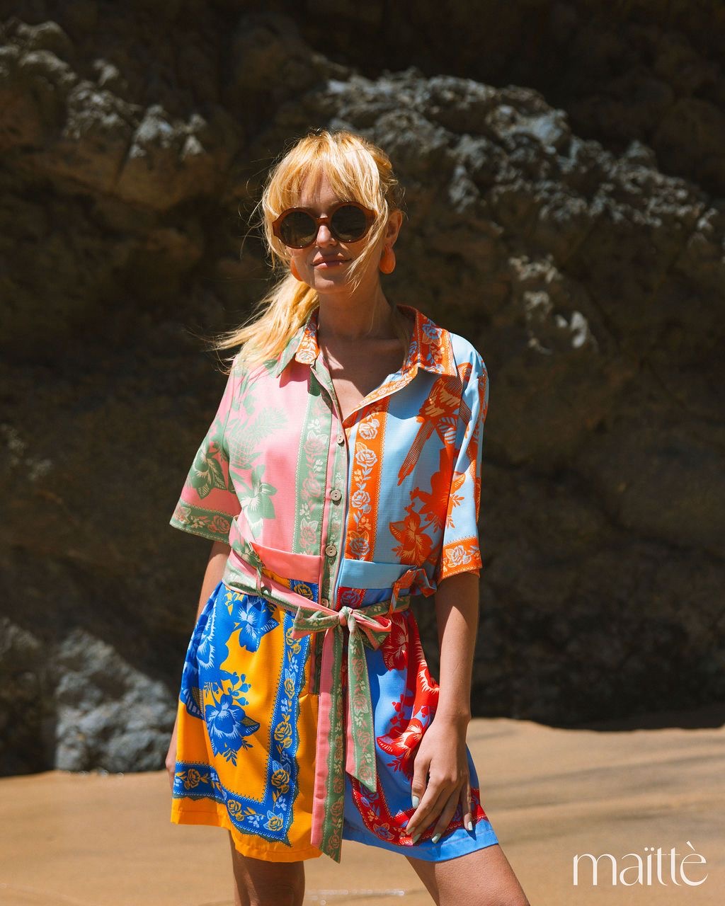 MACACÃO ZÉLIA Vestido curto colorido com padrão floral e de pássaros usado por mulher com óculos escuros
