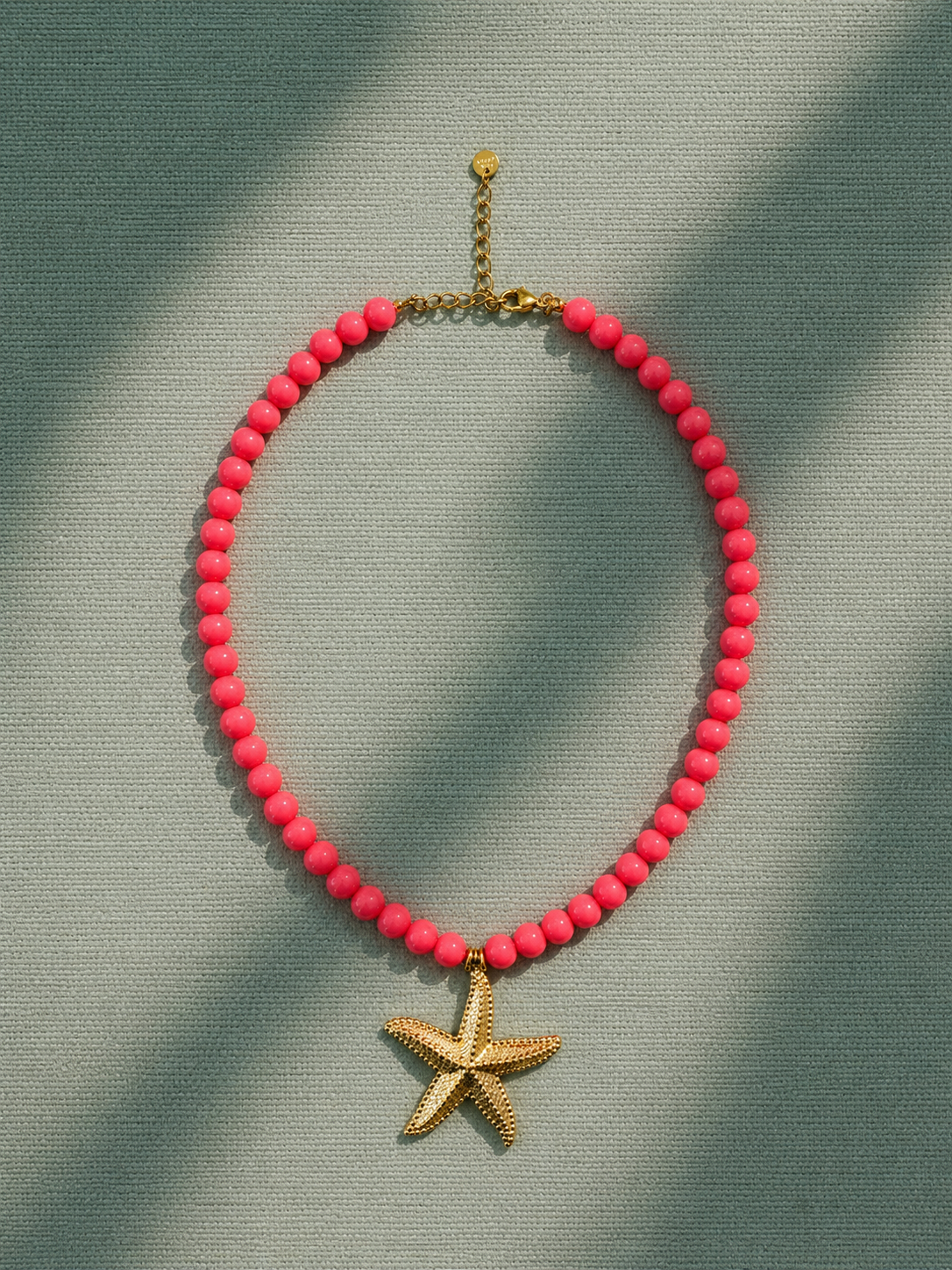 COLAR TRUTA Colar com contas rosa fluorescente e pendente de estrela-do-mar dourada