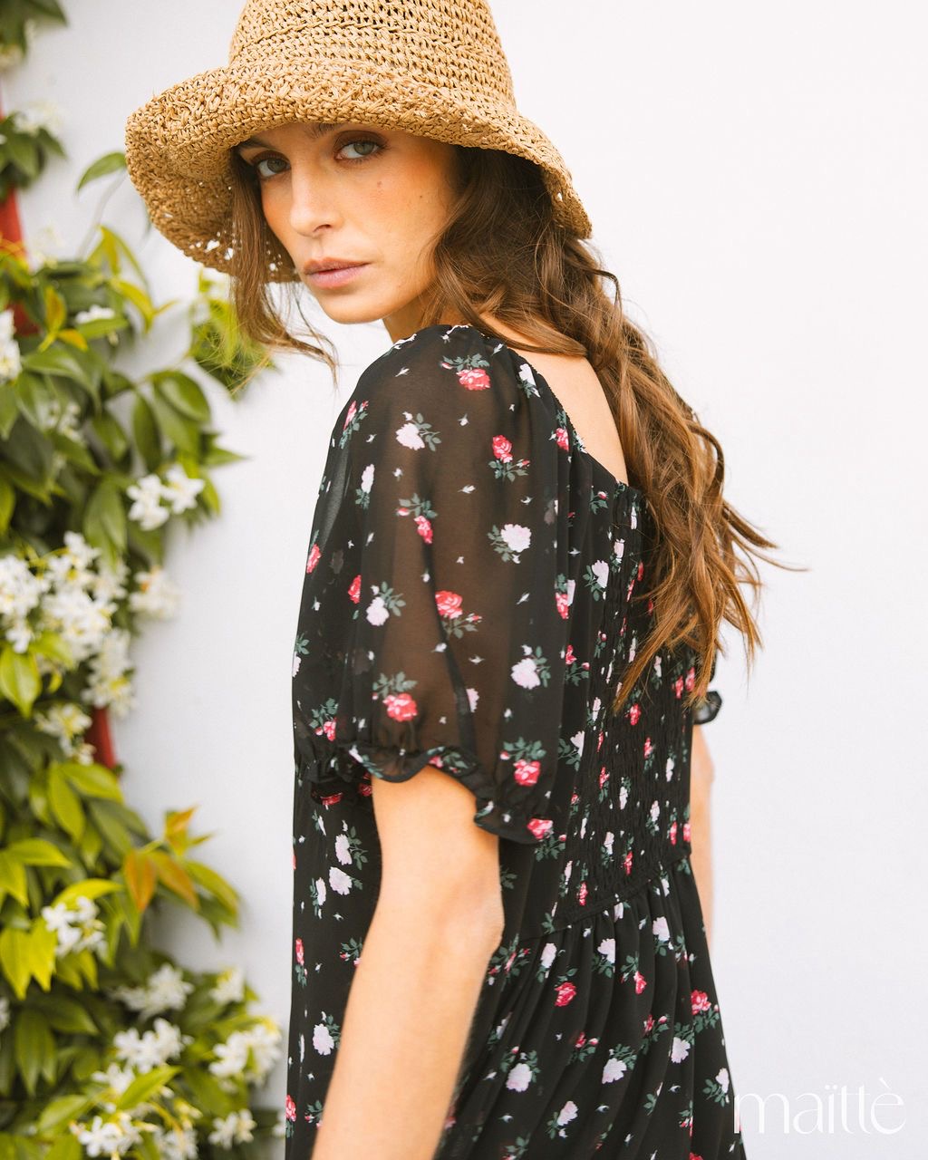 VESTIDO ZÉ Vestido feminino preto com padrão floral e mangas bufantes ao ar livre com chapéu de palha