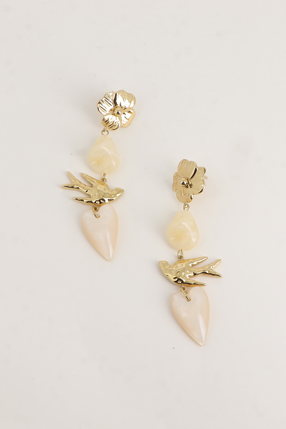 BRINCOS ANALICE Brincos pendentes dourados com flor, pássaro e pedras creme e branco perolado