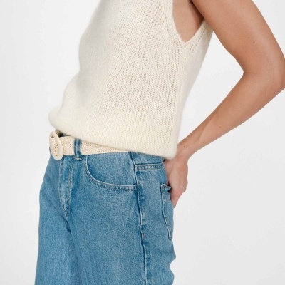 Top de malha creme com cinto e jeans azul claro