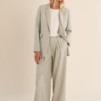 Conjunto de blazer e calças cinza claro com t-shirt branca e ténis brancos