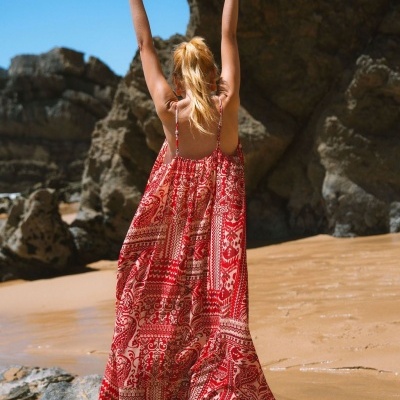 Vestido comprido vermelho e branco com padrão, alças finas, em praia rochosa
