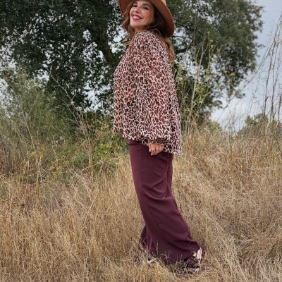 Mulher com roupa de padrão animal em campo seco