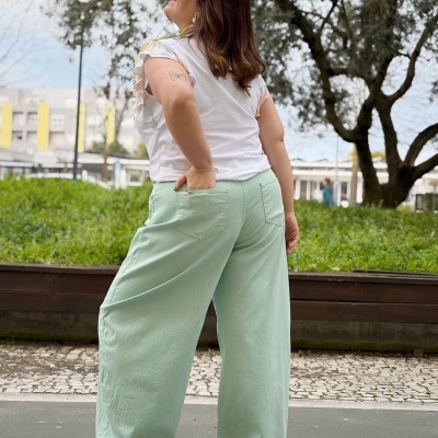 Calças largas verdes com bolsos traseiros e t-shirt branca com mangas curtas estampadas
