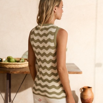 Camisola sem mangas verde e bege com padrão ondulado e calças brancas com padrão floral