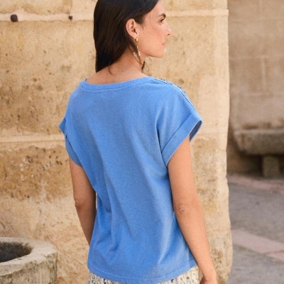 Camiseta azul claro de costas com calças estampadas em ambiente urbano