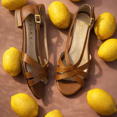 Sandálias de senhora castanhas com tiras cruzadas rodeadas por limões amarelos