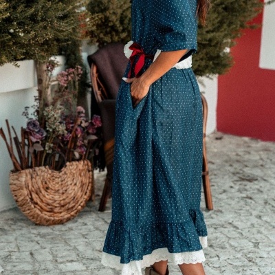 Vestido azul com padrão de pontos brancos e cinto branco e vermelho