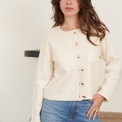 Mulher com casaco creme de malha e calças de ganga azul clara