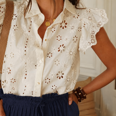 Camisa branca de algodão com flores recortadas e saia azul com textura franzida