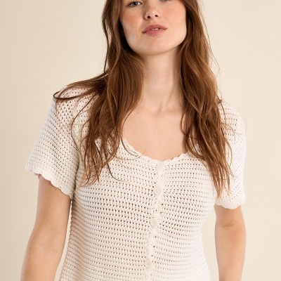 Camisola branca de malha com botões e padrão de pontos em mulher