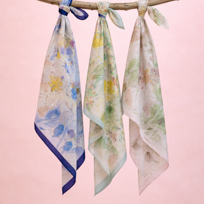 Três lenços florais pendurados num ramo de madeira