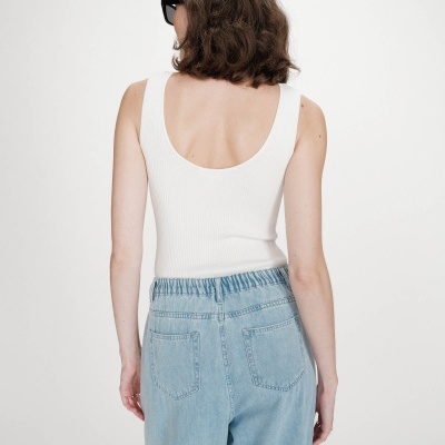 Pessoa de costas com camisola branca e calças de ganga azul claro