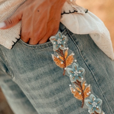 Calças de ganga com bordados florais e pérolas junto ao bolso