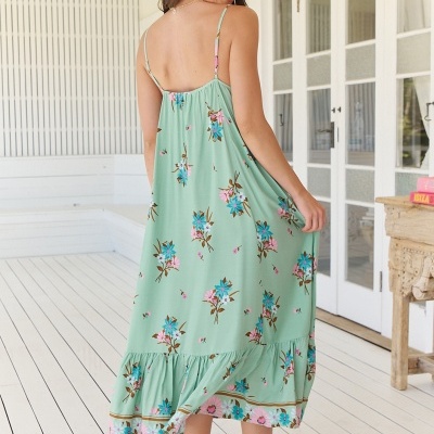 Vestido comprido verde claro com padrão floral azul e rosa, visto de costas