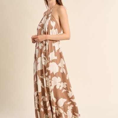 Vestido comprido castanho claro com padrão floral branco e sandálias castanhas.